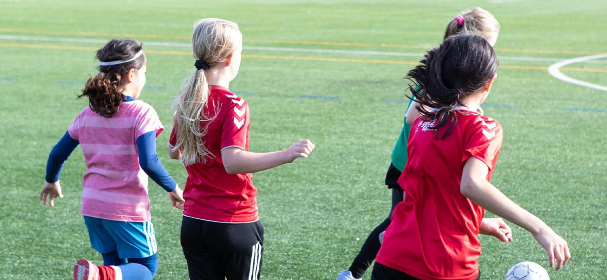 Piger spiller fodbold udendørs